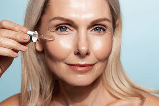 Smiling mature woman applying a serum, highlighting healthy, glowing skin. For ZO Skin Health anti-aging skincare products.